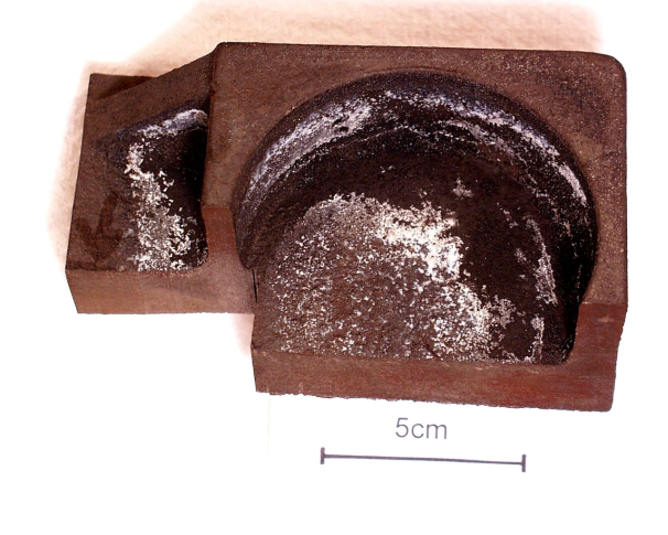 Fig. 1: Casting section with the well visible white cover, material: EN-GJS 400-18; % C = 3.58; % Si = 2.71; % Mn = 0.22; % Mg = 0.045; mold material: furan resin