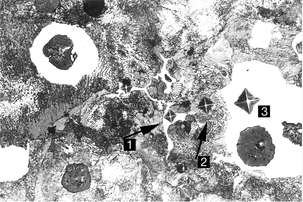 Bild 2: Korngrenzenkarbide; Mikrohärteeindrücke zur Kennzeichnung der Härteunterschiede, 1 = Karbid; 2 = Perlit; 3 = Ferrit,Vergrößerung 300:1, geätzt mit HNO3