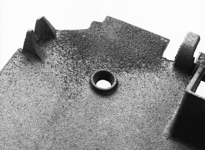 Bild 4: Festanhaftende Sandschicht an einem dünnwandigen Gussteil aus GJL (Quelle: Handbuch der Gussfehler, S&amp;B Industrial Minerals GmbH, Marl)